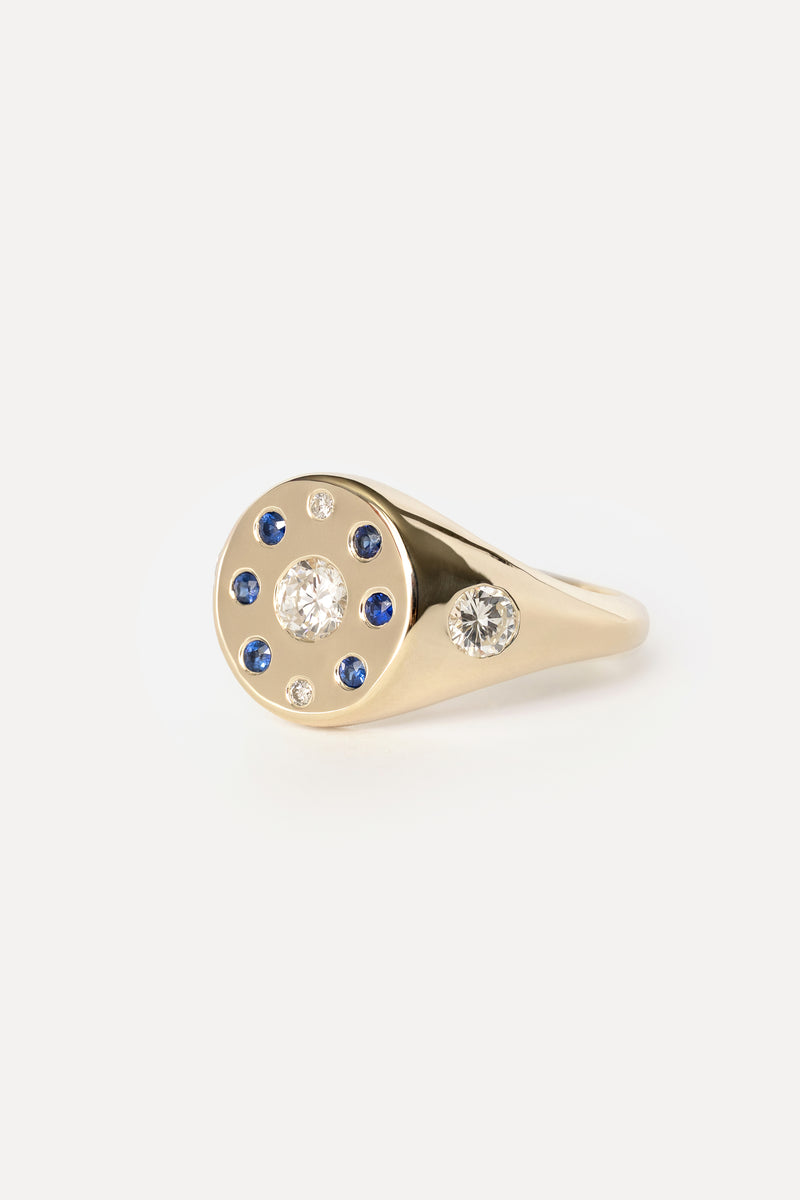 Signet ring with sapphires and diamonds in yellow gold on a white background