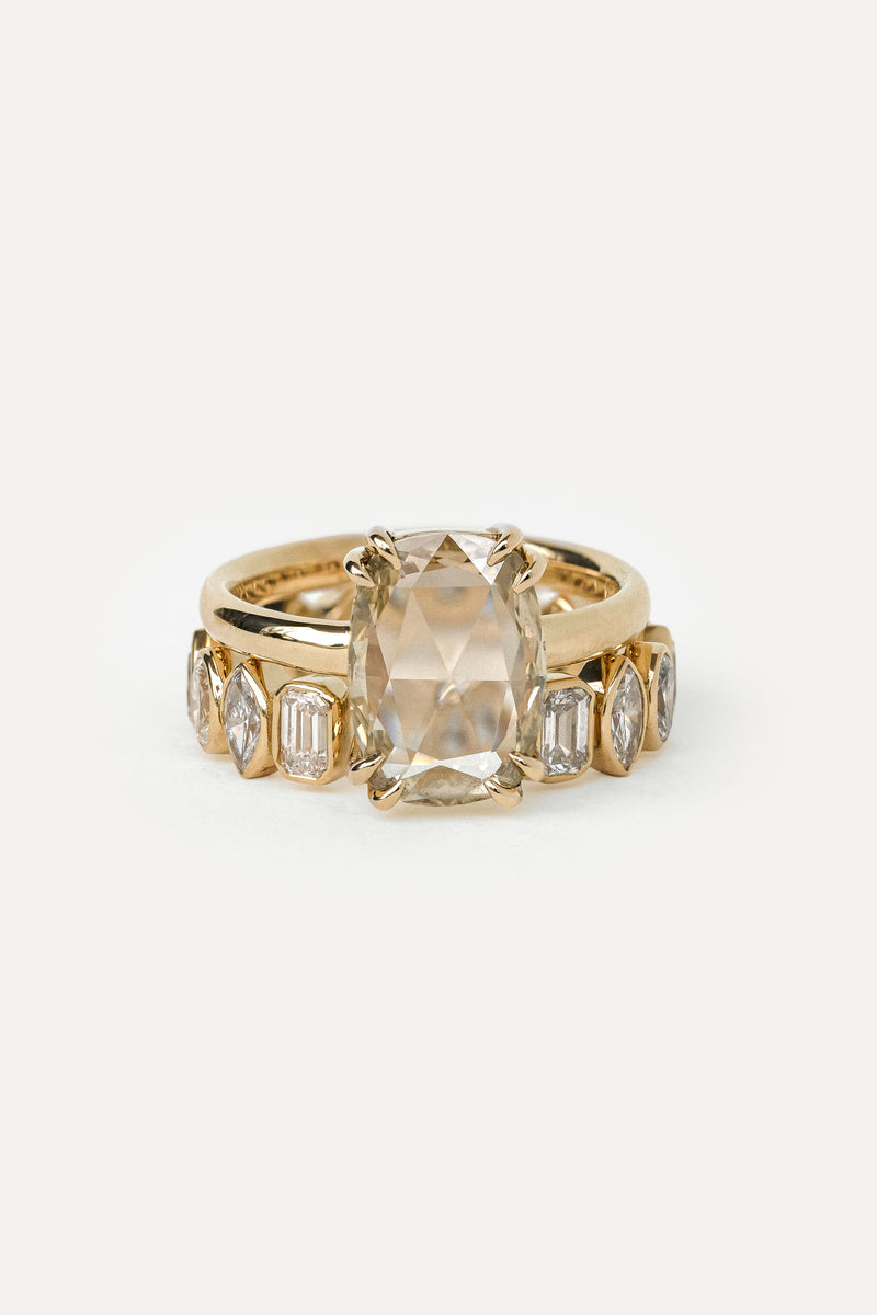 Yellow gold engagement ring and wedding band set with large central diamond and smaller stones on a white background