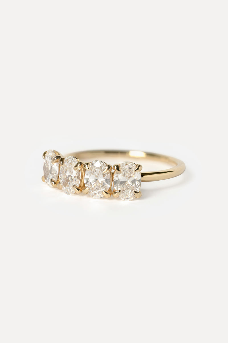 Gold ring with four diamonds on a white background