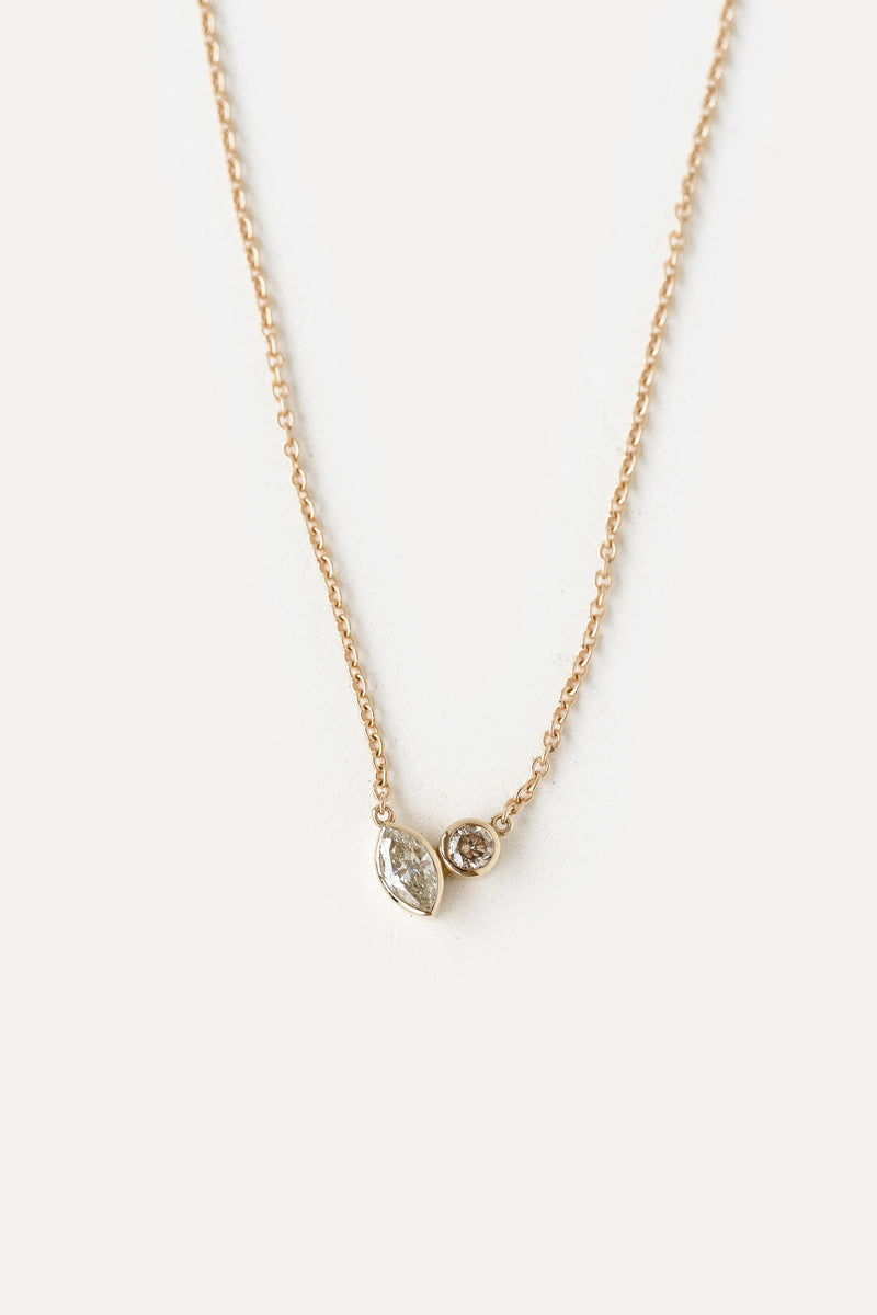 Yellow gold necklace in a 'Toi et Moi' style pendant on a white background