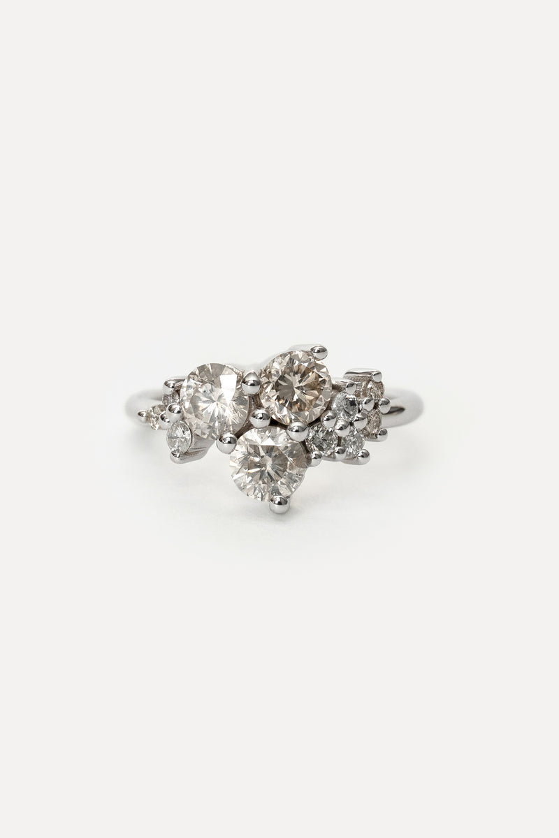 White gold ring with a cluster of prong set diamonds on a white background