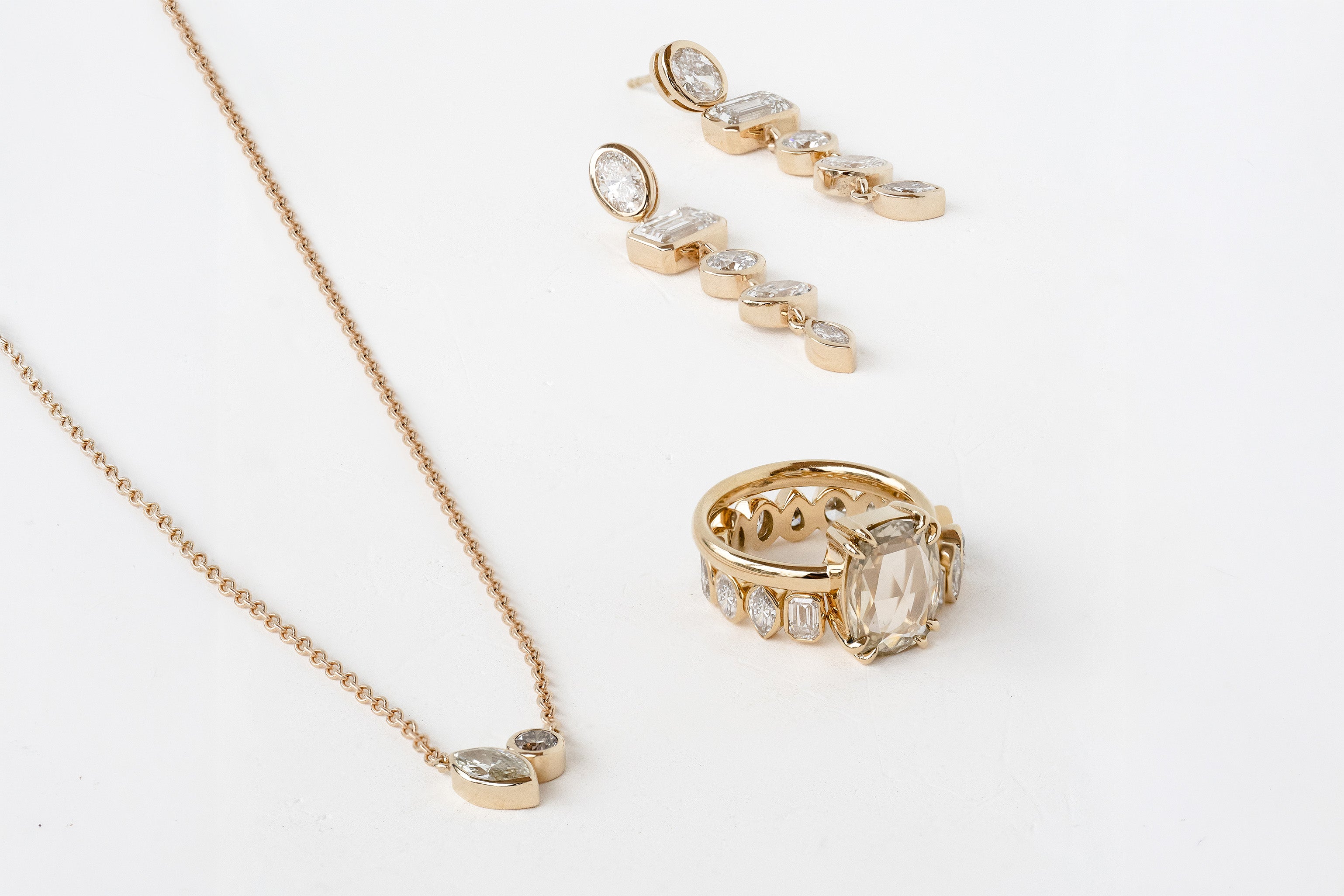 Gold jewelry set with necklace, ring, and earrings on a white background
