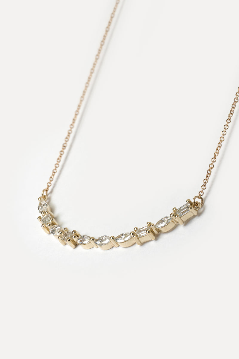Delicate gold necklace with lab diamonds on a white background