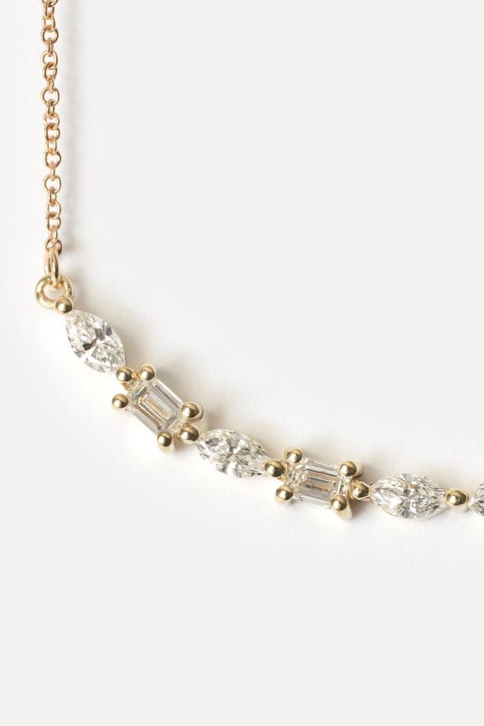 Delicate gold necklace with lab diamonds on a white background