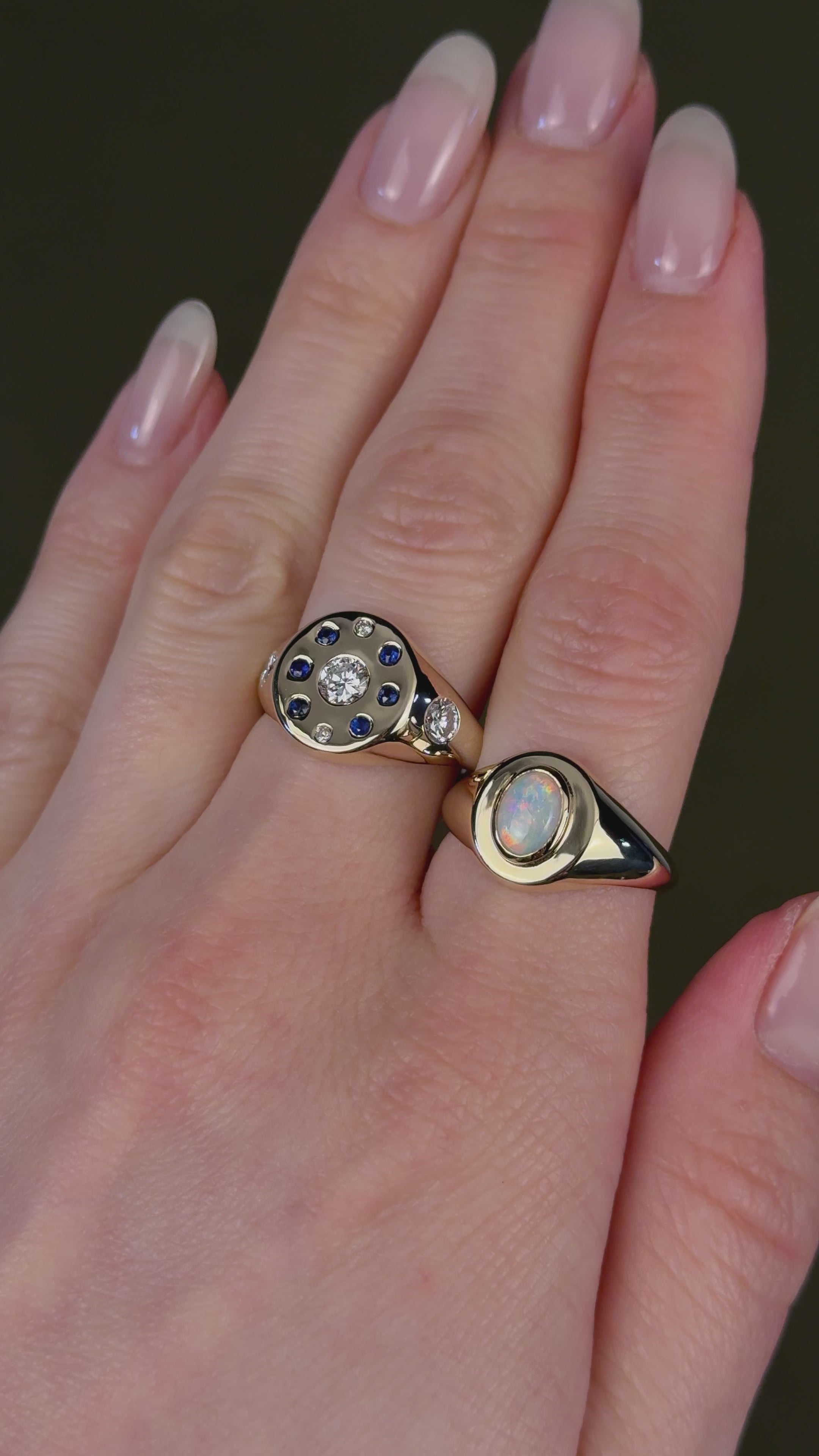 Model video of a women's hand with two yellow gold signet rings made with customer's heirloom stones