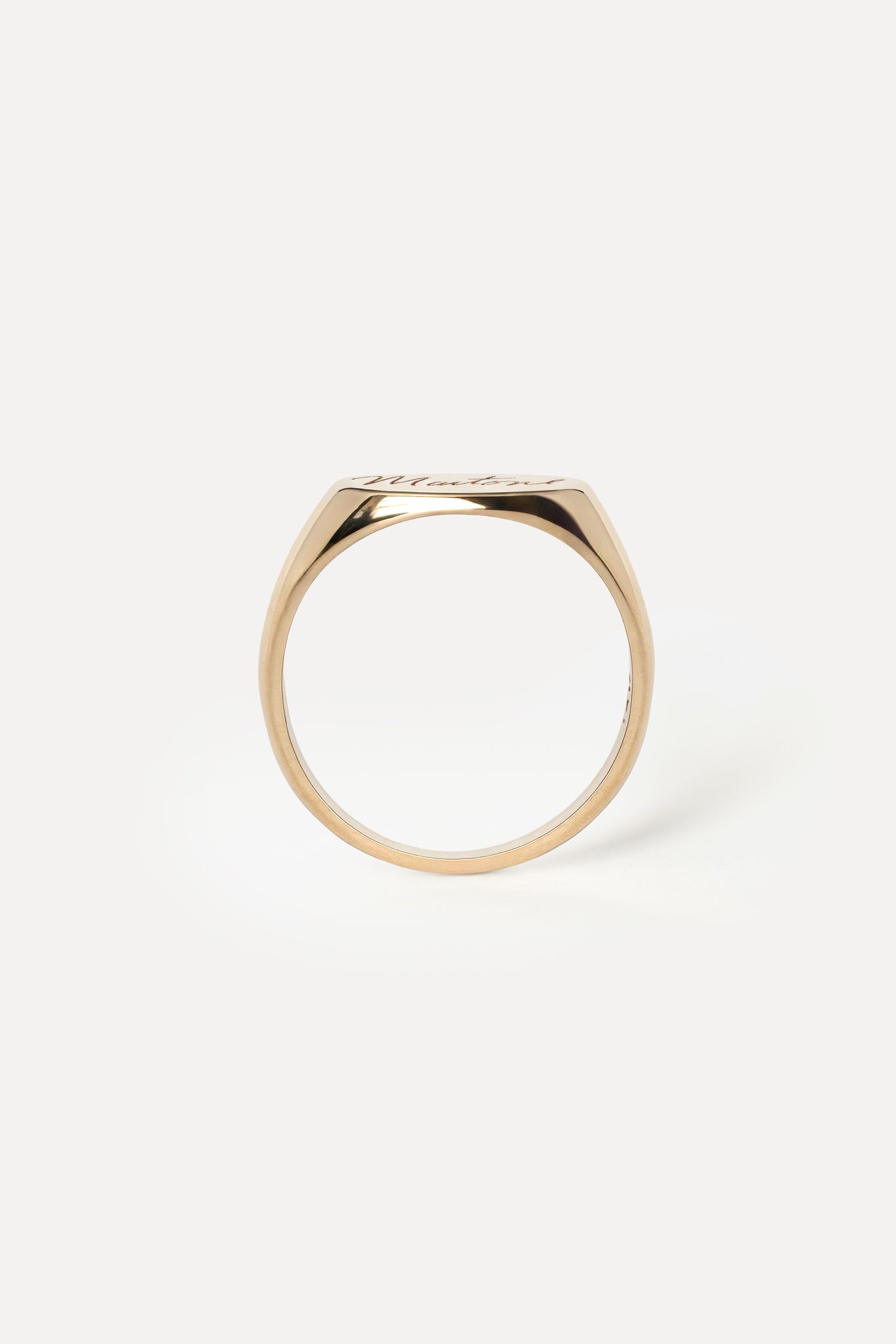 Profile of a yellow gold signet ring on a white background