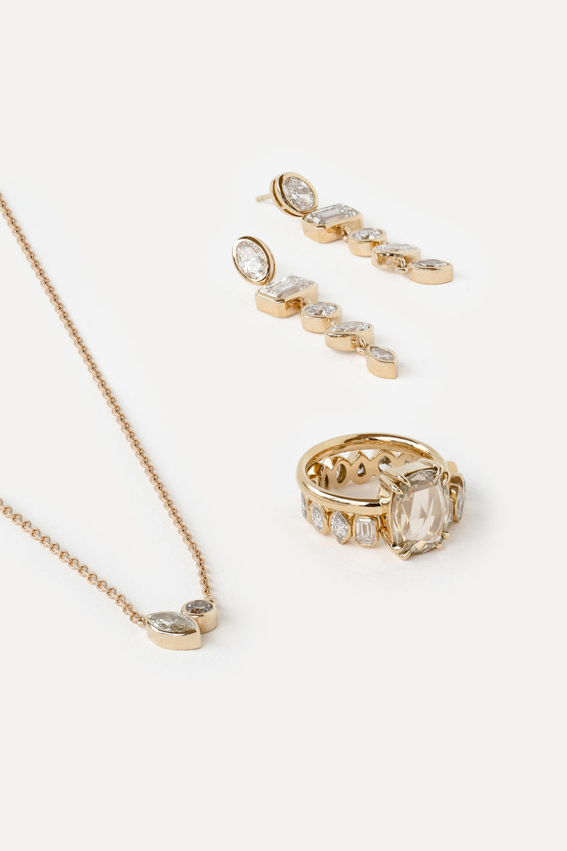 Gold jewelry set including necklace, ring, and earrings on a white background