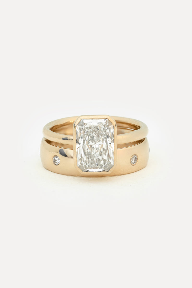 Engagement ring and wedding band set in yellow gold with a radiant cut lab diamond