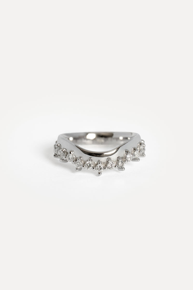 A white gold ring featuring a contour band adorned with small prong set diamonds, photographed on a clean white background.